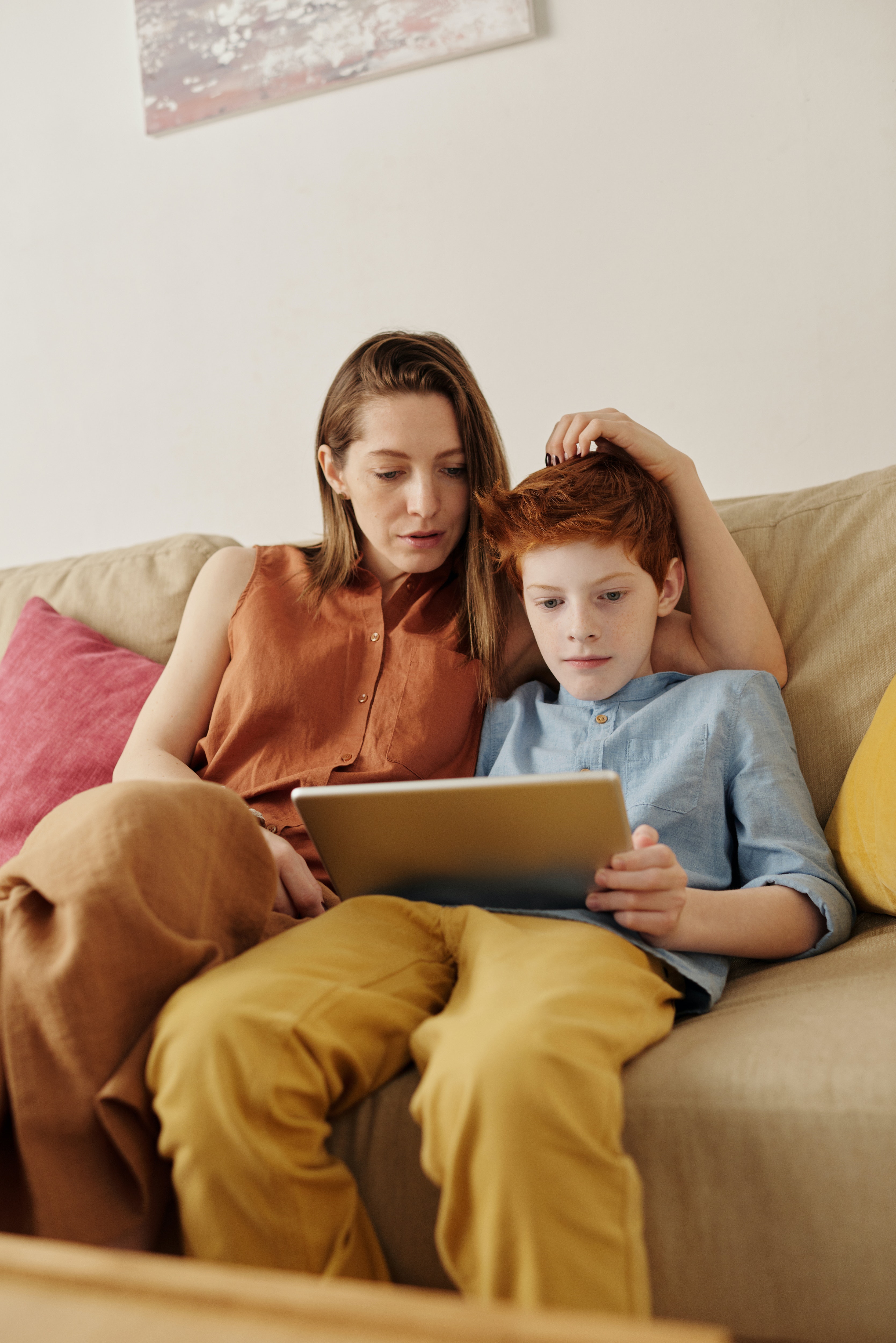 photo of woman and boy watching through tablet computer 4145349